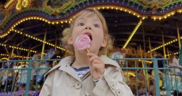 Una Bambina Tre Anni Lecca Una Caramella Colorata Parco Divertimenti — Video Stock