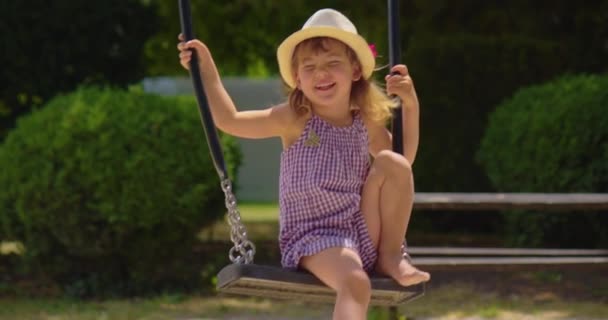 Een Klein Meisje Van Drie Jaar Een Hoed Jurk Rijdt — Stockvideo