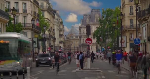 多くの自転車や歩行者がパリのメインストリートに沿って移動します 夏のラッシュ時にリヴォリ通りでの交通量が多い 車の交通や歩行者の川を渡ります タイムラプス — ストック動画