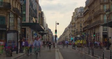 Birçok bisiklet ve yayalar Paris 'in ana caddesi boyunca hareket ederler. Paris 'teki ana Fransız caddesinde arabalar ve insanlar var. Şehir trafiği, trafik ışıkları ve trafik işaretleri. İnsanlar aceleyle işe gidiyor.
