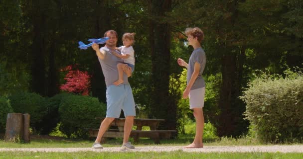 Папа Сын Играют Парке Летний Солнечный День Голубой Самолет Руках — стоковое видео