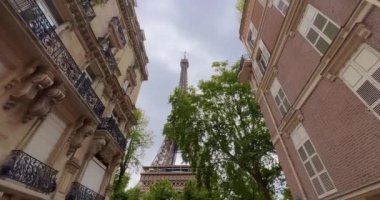 Arka planda Eyfel Kulesi olan en popüler sokak ve fotoğraf mekanı. Yazın Paris 'te küçük bir caddeden ünlü Eyfel Kulesi' nin romantik manzarası. Geniş yatay görünüm.