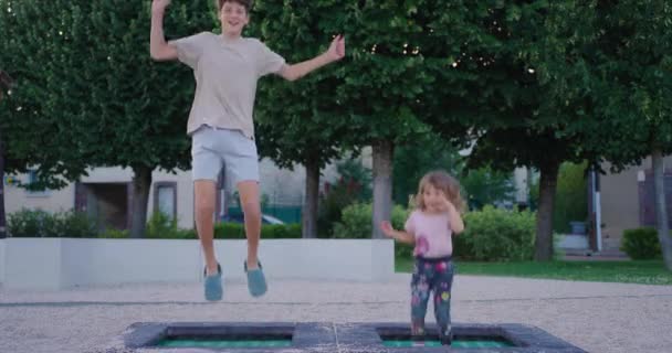 Счастливые Дети Прыгают Высоко Батуте Парке Брат Сестрой Прыгает Батуте — стоковое видео