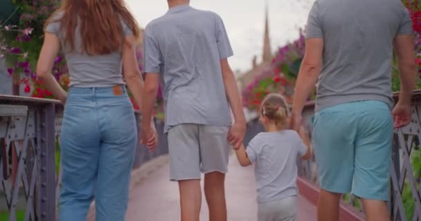 Pozytywni Rodzice Dzieci Spacerujący Most Kolorowymi Kwiatami Szczęśliwa Rodzina Spędza — Wideo stockowe