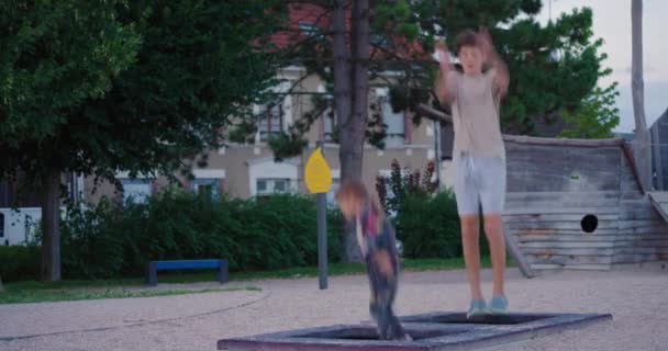Mutlu Çocuklar Parktaki Trambolinde Çok Yükseğe Zıplar Erkek Kız Kardeşi — Stok video