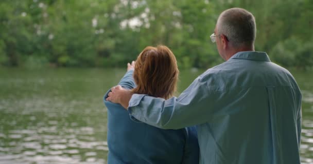 Άντρες Και Γυναίκες Αγκαλιάζονται Δίπλα Στο Νερό Και Βλέπουν Ηλιοβασίλεμα — Αρχείο Βίντεο