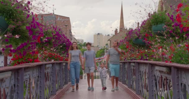 Positieve Ouders Kinderen Wandelbrug Met Kleurrijke Bloemen Gelukkig Gezin Brengt — Stockvideo