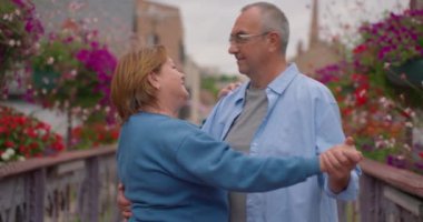 Sonbahar parkında dans eden mutlu yaşlı çift. Sonbahar kenti parkında dans eden ve gülümseyen neşeli, aktif emekli erkek ve kadın portresi..