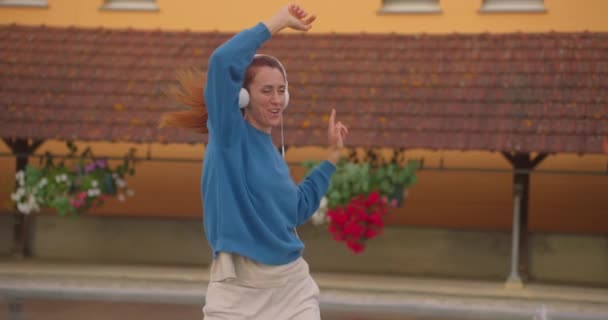 Счастливая Женщина Танцует Городской Улице Наслаждаясь Музыкой Через Наушники — стоковое видео