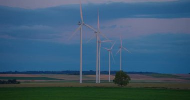 Beyaz rüzgar türbinleri rüzgardan döner. Rüzgar enerjisi dünya çapında yenilenebilir bir yeşil enerji kaynağıdır. Rüzgar değirmenleri. Sürdürülebilir enerji üretimi, temiz enerji, yel değirmeni.