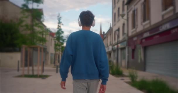Attraktiver Teenager Läuft Die Straße Entlang Und Hört Musik Über — Stockvideo