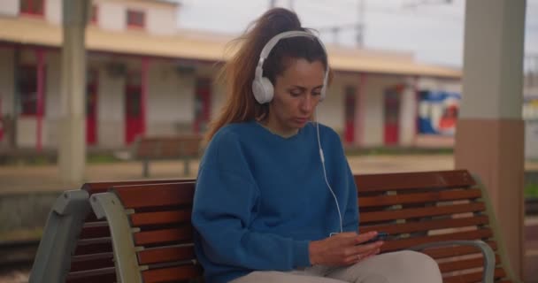 Menina Ouvindo Música Com Fones Ouvido Enquanto Espera Trem Estação — Vídeo de Stock