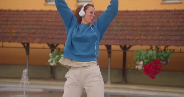Boldog Táncol Város Utcájában Élvezi Zenét Fülhallgatón Keresztül — Stock videók