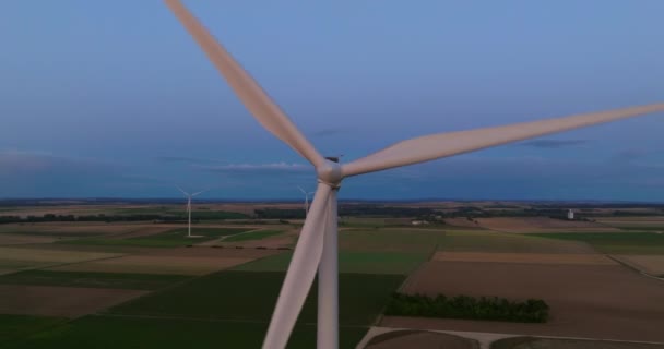 再生可能エネルギー 持続可能な開発 環境に優しいコンセプト フィールド上の回転風の発電機が付いている素晴らしい緑の風景 夜景に美しい白い風力タービン — ストック動画