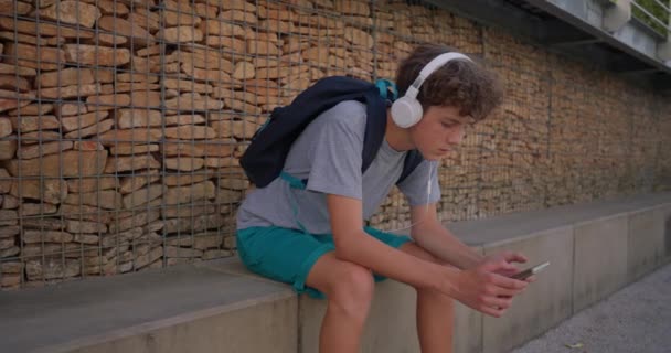 Ein Niedlicher Teenager Sitzt Einem Park Auf Einer Bank Und — Stockvideo