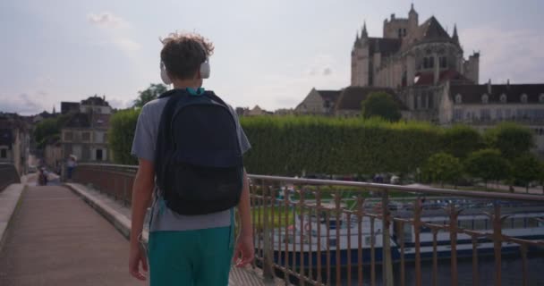 Ένας Έφηβος Στο Παρασκήνιο Μιας Όμορφης Παλιάς Πόλης Ακουστικά Ταξιδεύει — Αρχείο Βίντεο