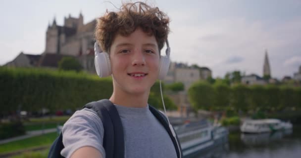 Ein Niedlicher Teenager Tourist Mit Kopfhörern Geht Durch Die Stadt — Stockvideo