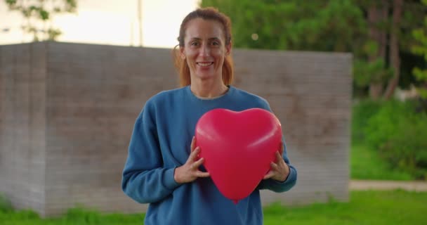 Retrato Mujer Feliz Con Globo Corazón Rojo Sosteniendo Sus Manos — Vídeos de Stock