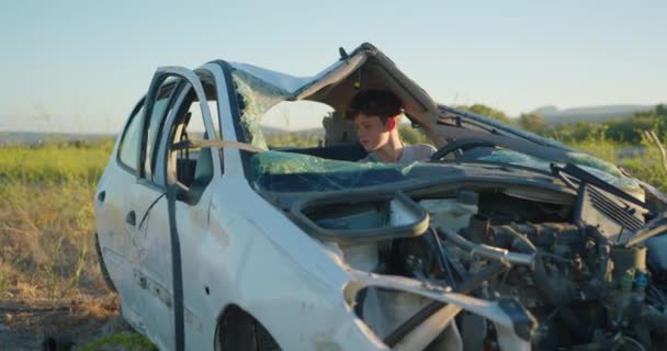 車の運転手は事故後にショックを受けた 高速道路の近くで破壊された車 未経験のドライバーで事故が発生しました 車両の完全破壊による不確実なイベント — ストック動画