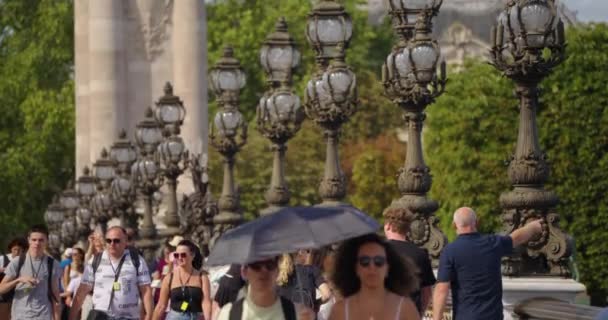 フランス 2023年7月30日 美しい雲を持つ青空に対して黄金の彫像を持つパリのグランドアレクサンダー橋 認識できない人々が通りを歩き グランドアレクサンダー橋の群衆 — ストック動画
