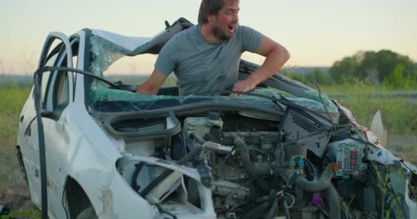 Водитель Разбитой Машины Находится Шоке После Аварии Разрушенная Машина Рядом — стоковое видео