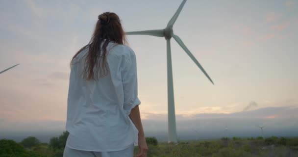 Rüzgar Değirmenlerinin Arka Planında Uzun Kıvırcık Saçlı Yenilenebilir Elektrik Üreten — Stok video