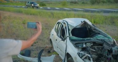 Kadın sürücü, araba kazasından sonra kaza yapan aracın cep telefonu kamerasından acil yardım çağrısı yapıyor. Yol güvenliği ve sigorta kavramı.