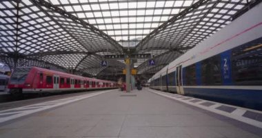 Köln, Almanya Köln, Köln Merkez İstasyonu Koeln Hauptbahnhof platformunda yürüyen insan ve tren saatleri.