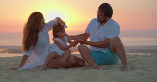 Супружеская Пара Дочерью Сидящей Берегу Океана Золотые Часы Наслаждается Временем — стоковое видео
