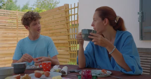 Usmívající Matka Svým Dospívajícím Synem Mluví Snídaně Venku Svého Doma — Stock video