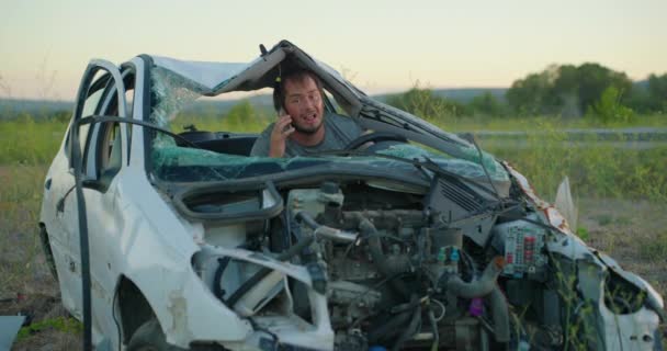 一个男子坐在车里 在车祸中被毁 他试图打电话给保险公司寻求帮助 处于紧张和震惊状态的人 — 图库视频影像