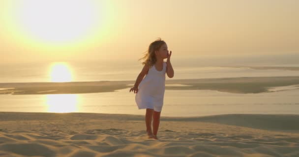 Uma Menina Bonita Vestido Branco Caminha Descalça Areia Pôr Sol — Vídeo de Stock