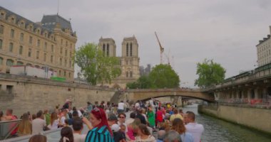 Fransa, Paris, 01 Ağustos 2023: Paris Canal tur teknesi Seine ve Notre-Dame de Paris katedralinde yeniden inşa ve yenileme çalışmaları sürüyor.