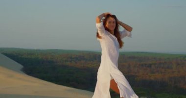 Slim Woman in White Shirt Walks Coast Sea in Sunset 'de. Kaygısız Kız Yaz Tatili Denizi 'nde eğleniyor. Seyahat Konsepti. Güzel Kadın Modeli Kum Kumsalı Dinleniyor.