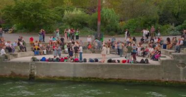 Fransa, Paris, 01 Ağustos 2023: Yaşlı Parisliler Seine Nehri 'nin setinde dans edip eğleniyorlar. Nehirden geçen bir geminin setin manzarası.