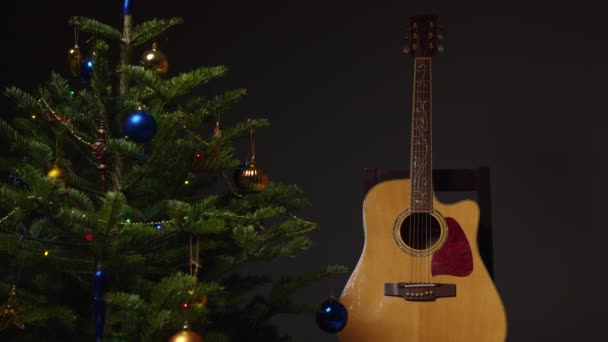 Obok Ozdobionej Choinki Stoi Drewniana Gitara Akustyczna Wakacyjna Koncepcja Komfortu — Wideo stockowe