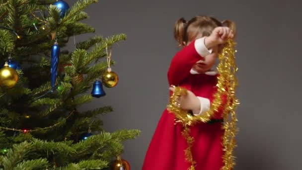 Een Klein Meisje Versiert Kerstboom Door Sorteren Door Feestelijke New — Stockvideo