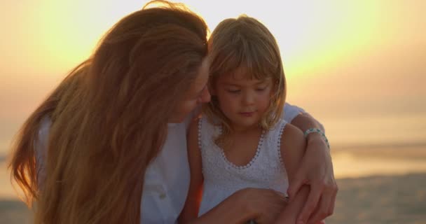 Young Mother Hugs Kisses Little Daughter Seaside Ocean Sun Sunset — Stock Video