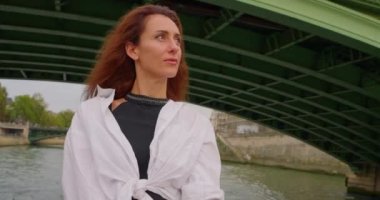 Turist gemisiyle gezen bir kız Seine nehri boyunca Paris manzarasının tadını çıkarıyor..