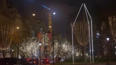 Fransa 'nın başkenti Paris' te kutlama renklerinde dekorasyonlar. Paris 'te Noel. Güzel bir akşam, Paris Noel için dekore edilmiş, şehir merkezinde trafik var..