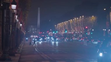 Fransa 'nın başkenti Paris' te kutlama renklerinde dekorasyonlar. Paris 'te Noel. Güzel bir akşam, Paris Noel için dekore edilmiş, şehir merkezinde trafik var..