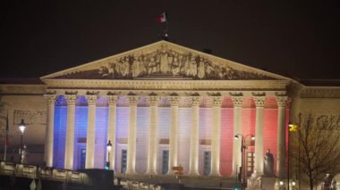 Fransız Ulusal Meclisi binası ve Fransız bayrağı. Paris 'in merkezindeki bir binanın mimari aydınlatması.