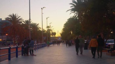 Alicante, İspanya, 17 Aralık 2023: İnsanlar İspanya 'nın Kosta Blanca kentindeki Alicante şehrinde akşam saatlerinde pitoresk bir ara sokakta yürüyorlar.