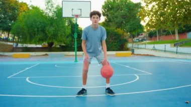 Ağır çekim sokak basketbolu. Basketbol antrenmanı yapan bir çocuk. Genç basketbol oynar. Sağlıklı yaşam tarzı ve hobi anlayışı. Basketbol topuna vuran tatlı bir çocuk..