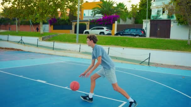 スローモーションストリートバスケットボール バスケットボールの練習をしている少年 ティーンエイジャーはバスケットボールをしている 健康的なライフスタイルと趣味のコンセプト かわいい子供がバスケットボールボールを打つ — ストック動画