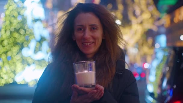 一个卷发的成年女子拿着蜡烛的画像 圣诞气氛 巴黎街头装饰着圣诞光彩夺目的装饰和背景灯 — 图库视频影像