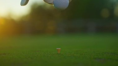 Golfçü golf sahasındaki golf sahasına golf topu koyuyor. Kapatın. İnsanlar, spor, boş zaman aktivitesi, eğlence ve yaşam tarzı. 