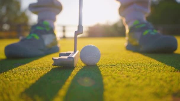 高尔夫比赛中 高尔夫球手在阳光下 在球员的腿和草的衬托下击球 — 图库视频影像