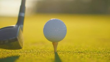 Yavaş çekimde golf sporu konsepti, golf sahasında golfçülerin golf sahasında kazanmak için deliğe vurması günbatımında güzel bir çim yoldur. Yeşil çimlere yakın şut atılıyor. Yazın rahatlamak için oynayan oyuncu için..