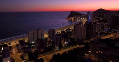 İspanya 'nın Benidorm kentindeki kıyı binalarının hava manzarası. Benidorm 'un güzel mavi saat hava manzarası. Huzurlu plajlar ve pürüzsüz Akdeniz 'de sokak lambaları uzakta parlıyor..